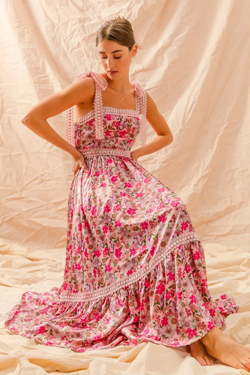 This is a long beautiful pink floral dress with tie shoulder straps that are thick.